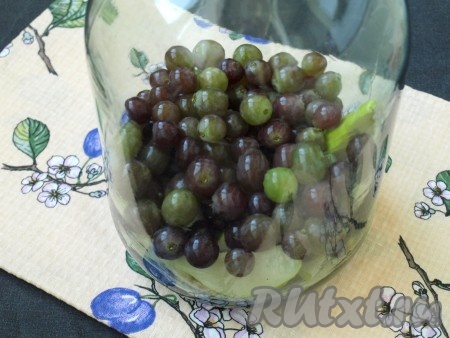 На дно чистой стерильной банки выложить дольки груш, сверху насыпать виноград.
