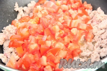 Затем добавить в сковороду к фаршу измельчённые помидоры.