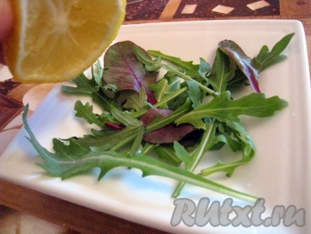 Подавать салат эффектнее порционно - 4-5 порций. На тарелку выложить салатные  травки и сбрызнуть их лимонным соком.