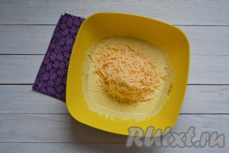 Сыр натереть на средней терке, небольшую часть натёртого сыра оставить для посыпки верха пирога. Остальной сыр соединить со смесью яиц и сметаны, перемешать венчиком или ложкой.