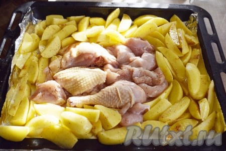 Выложить кусочки курицы к картофелю в центр противня (или формы для запекания).