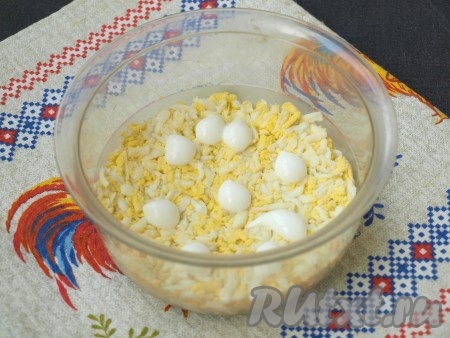 Варёные яйца натереть на тёрке и выложить поверх лука, смазать майонезом.