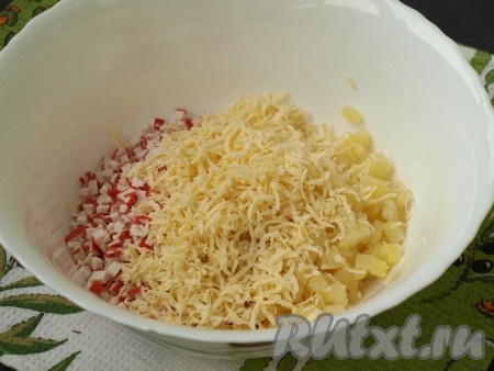 Крабовые палочки и ананасы поместить в миску, добавить к ним сыр, натертый на мелкой тёрке.