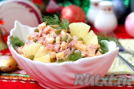 Вкусный и быстрый салат с ветчиной, сыром и ананасами подать к столу в красивом салатнике.