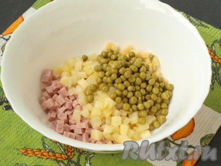 Ветчину, сыр и ананасы сложить в салатник, добавить консервированный горошек.
