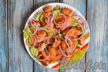 Очищенный красный (или салатный) лук нарезать очень тонкими полукольцами и выложить на салат с мидиями и овощами.
