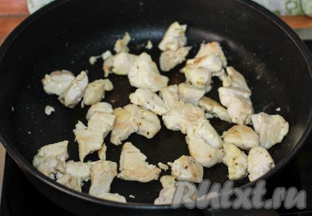 Сковороду разогреть, налить растительное масло, выложить кусочки куриного мяса, обжарить на сильном огне до золотистого цвета со всех сторон, чтобы сок остался внутри мяса. Слегка посолить, поперчить, добавить приправу для курицы.
