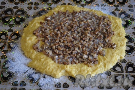 На пласт теста ровным слоем выложить ореховую начинку. 

