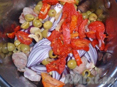Добавить к мясу лук, оливки и вяленые томаты.