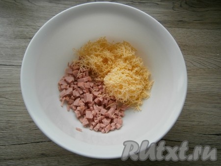 К сосискам, нарезанным маленькими кубиками, добавить сыр, натертый на средней или мелкой терке.
