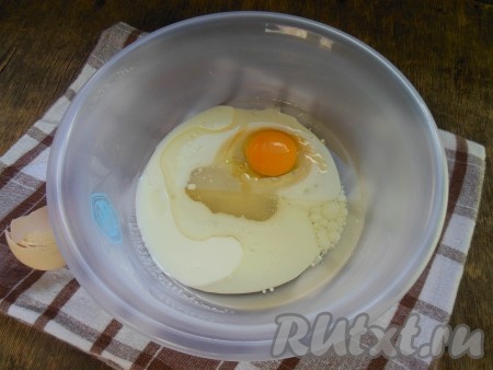 В миску добавьте кефир, куриное яйцо, щепотку соли, 1 столовую ложку сахара и растительное масло.
