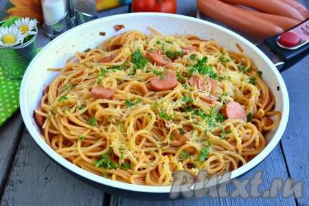 Подать вкуснейшие спагетти, приготовленные с сосисками, к столу в горячем виде.