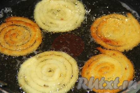 Жарить картофельные спиральки до золотистого цвета на среднем огне с двух сторон.
