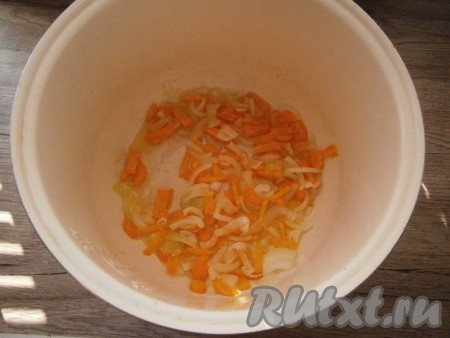 Очищенные лук и морковь нарезать небольшими кусочками, выложить в чашу мультиварки, влить растительное масло. Выставить программу "Жарка" или "Выпечка" на 10 минут. Помешивая овощи, дать им обжариться.

