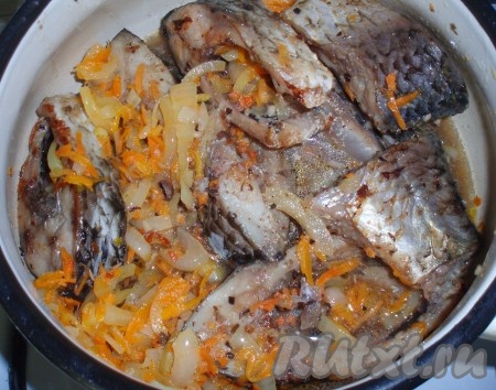 Залить кусочки карася с овощами пивным маринадом, в котором мариновалась рыба, накрыть посуду крышкой и тушить на маленьком огне 15-20 минут.
