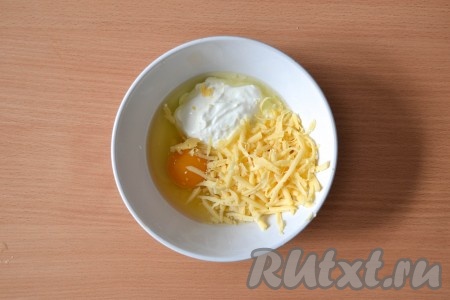 В миске соединить сметану, яйцо и твердый сыр, натертый на крупной терке, и тщательно перемешать с помощью вилки.
