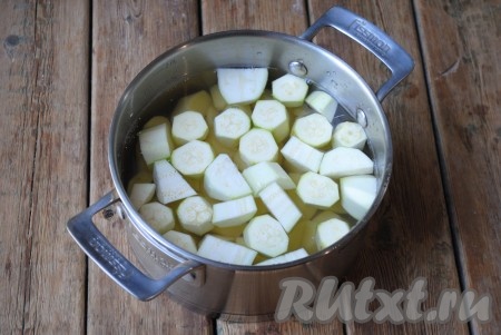 Картофель и кабачки нарезать средними кусочками и выложить в подходящую кастрюлю. Залить чистой холодной водой, чтобы она полностью покрывала овощи. 
