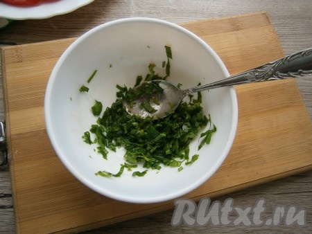 Зелень измельчить и выложить в глубокую тарелку. Всыпать к зелени щепотку соли, хорошо ложкой растереть.
