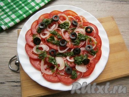Полить заправкой помидоры, сверху можно разложить оливки, нарезанные на колечки. Оставить закуску в прохладном месте на 15 минут.