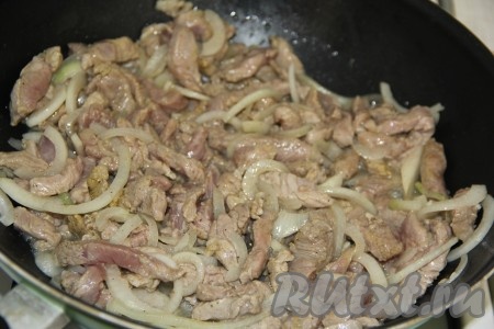 В сковороду налить растительное масло и хорошо разогреть, выложить мясо с луком и обжарить в течение 15 минут на среднем огне, иногда перемешивая.
