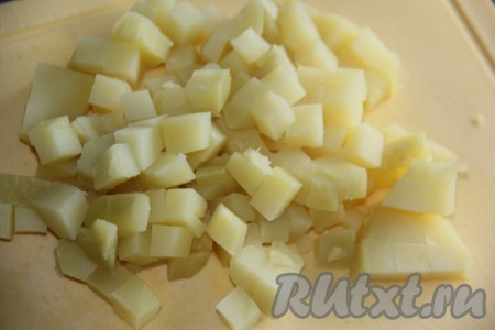 Картофель тщательно вымыть и отварить в кожуре до готовности (на это потребуется с начала кипения воды минут 25-30), затем воду слить, полностью остудить картофель.  Варёную картошку очистить, нарезать на кубики среднего размера.