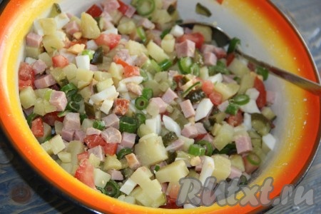 Соединить в глубокой миске нарезанные картофель, колбасу, солёные огурцы, помидоры, яйца и зелёный лук. Посолить салат, хорошо перемешать.