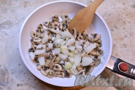 В сковороду с растительным маслом выложить нарезанные шампиньоны, посолить их немного и поперчить. Обжарить грибы на среднем огне, помешивая, в течение 3-4 минут, после чего добавить лук.

