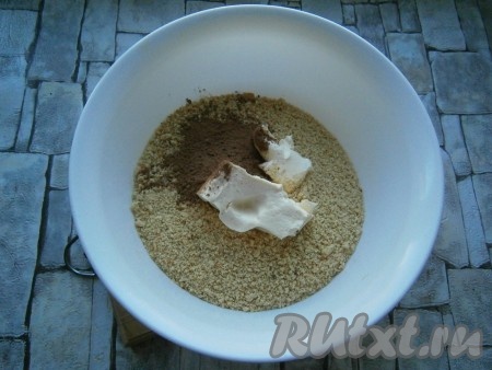 Пересыпать крошку в миску, добавить размягченное сливочное масло и какао-порошок.