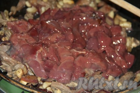На сковороду с сердечками, луком и грибами добавить куриную печень, нарезанную на кусочки.
