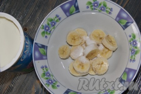 Банан очистить и нарезать на кружочки. Выложить банан в удобную миску для взбивания. Добавить сахарную пудру (я добавила 1 чайную ложку).
