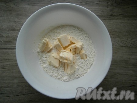Для приготовления коржиков 300 грамм муки просеять в миску, добавить нарезанное кусочками или натертое холодное сливочное масло.
