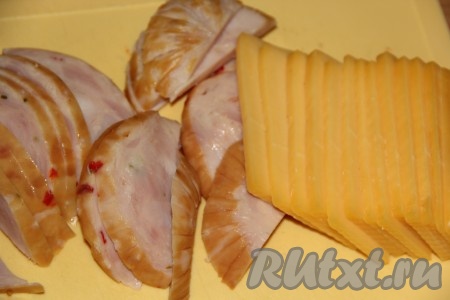 Колбасу и сыр нарезать на тонкие пластинки.

