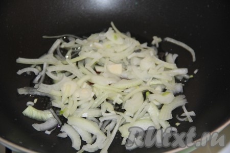 Морковь и лук очистить. В сковороду с высокими бортиками (или сковороду вок) влить немного растительного масла, выложить нарезанный тонкими полукольцами лук.
