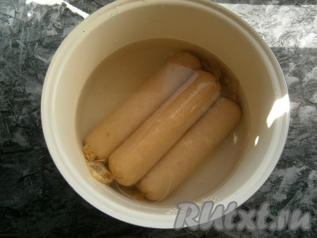 Сложить батоны колбасы в чашу мультиварки, залить холодной водой.