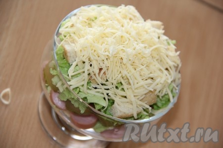 Выложить сыр поверх салата пышной шапкой. 