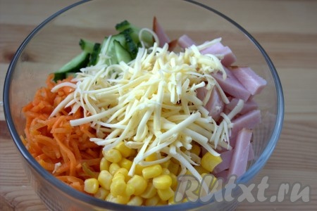 В салатнике соединить нарезанные огурец, колбасу, корейскую морковь и натёртый сыр. С консервированной кукурузы слить жидкость и добавить в салат.