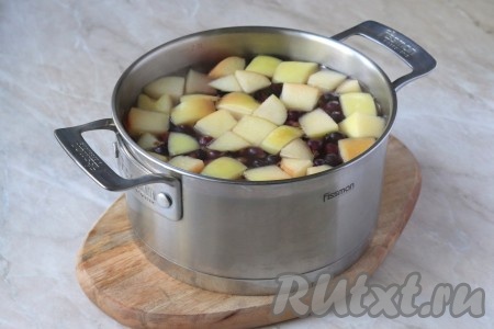 В кастрюле вскипятить воду и выложить подготовленные яблоко и смородину.
