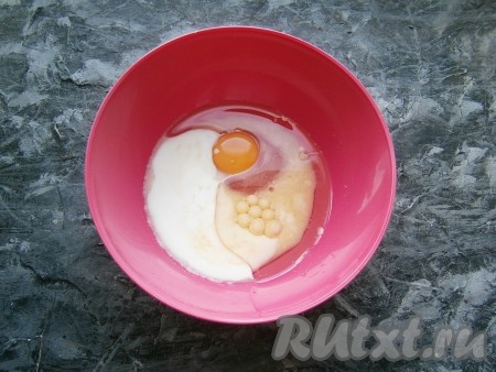 В миску влить кефир, молоко, растительное масло, добавить сырое яйцо.
