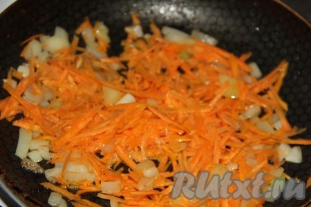 Затем к луку выложить морковь, натёртую на крупной тёрке, обжаривать на среднем огне минут 5, периодически перемешивая.

