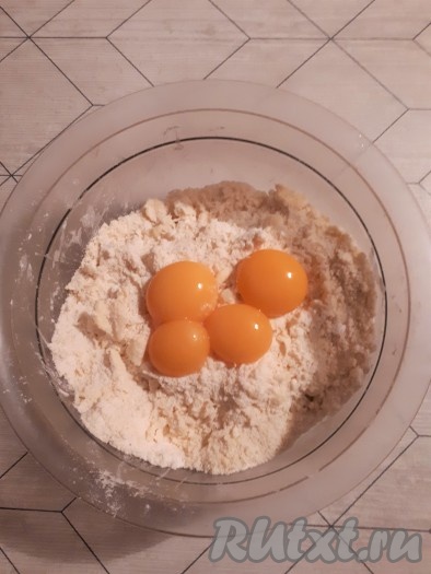 Разделить яйца на белки и желтки. Белки отправить в холодильник. Желтки добавить к крошке и быстро замесить тесто.
