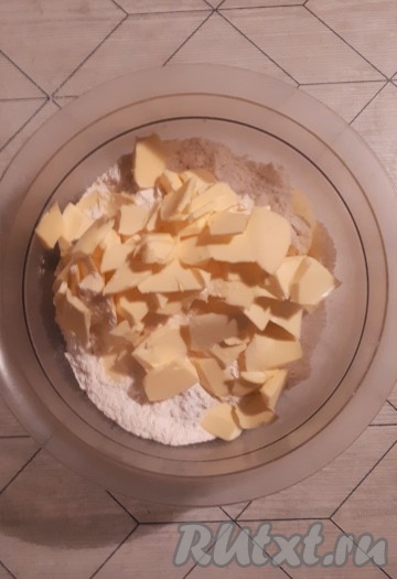 Просеять в миску муку с разрыхлителем и сахарной пудрой, затем добавить нарезанное на кусочки сливочное масло и перетереть получившуюся массу в крошку.
