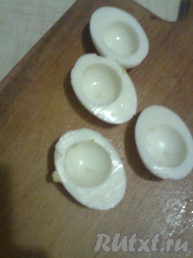 Для украшения салата "Мышки" отварить яйца вкрутую в течение 7-10 минут после закипания воды. Чтобы скорлупа не треснула, можно добавить в воду для варки яиц 1 столовую ложку уксуса 9%. Остудить сваренные яйца в холодной воде. Очистив от скорлупы, разрезать каждое яйцо на 2 части. Отделить желтки от белков. Для приготовления начинки для фарширования яиц 1 луковицу очистить, нарезать на кубики, обжарить на подсолнечном масле до золотистого цвета на среднем огне, дать остыть.
