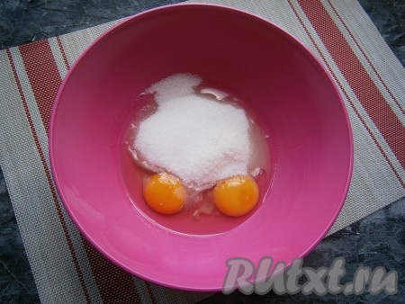 Сахар всыпать в глубокую миску, добавить 2 сырых яйца, ванильный сахар и щепотку соли.