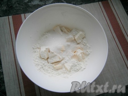 Приготовить тесто-основу: муку насыпать в миску, добавить нарезанное на кусочки холодное сливочное масло, всыпать сахар и щепотку соли.