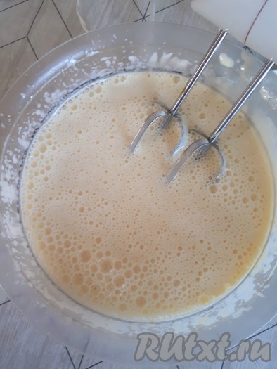Горячую молочно-масляную смесь тонкой струйкой влить в кремовую массу, продолжая взбивать миксером.
