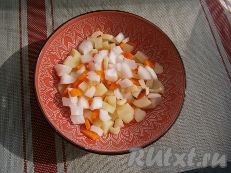 Затем достать миску с картошкой из микроволновки, добавить нарезанную кубиками морковь и нарезанный кусочками лук.
