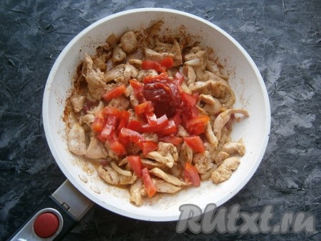 Обжаривать куриное мясо с овощами на среднем огне ещё 5-6 минут, иногда перемешивая, затем добавить один нарезанный помидор и томатный соус.
