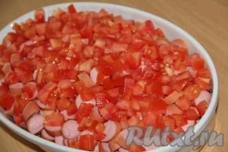 Поверх сосисок выложить вымытые помидоры, нарезанные на мелкие кубики.
