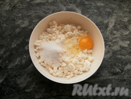 В творог добавить сырое яйцо, сахар и щепотку соли.