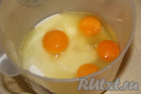 В достаточно глубокую ёмкость, удобную для взбивания миксером, насыпать сахар, добавить яйца.
